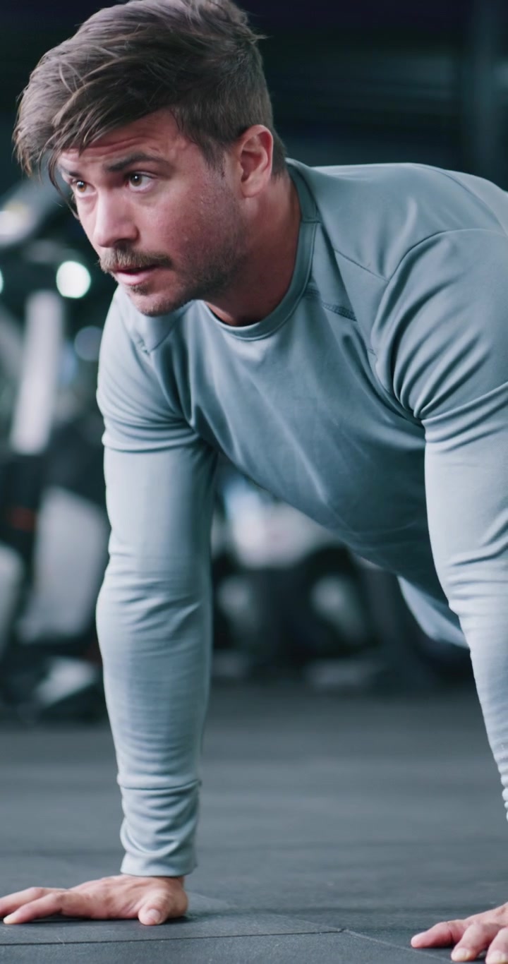 Young Man Performing Push-Ups in a Modern Gym