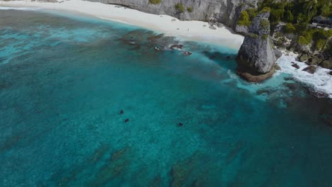 mantarrayas nadando en aguas azules poco profundas cerca de la playa de diamantes de la costa en nusa penida, antena