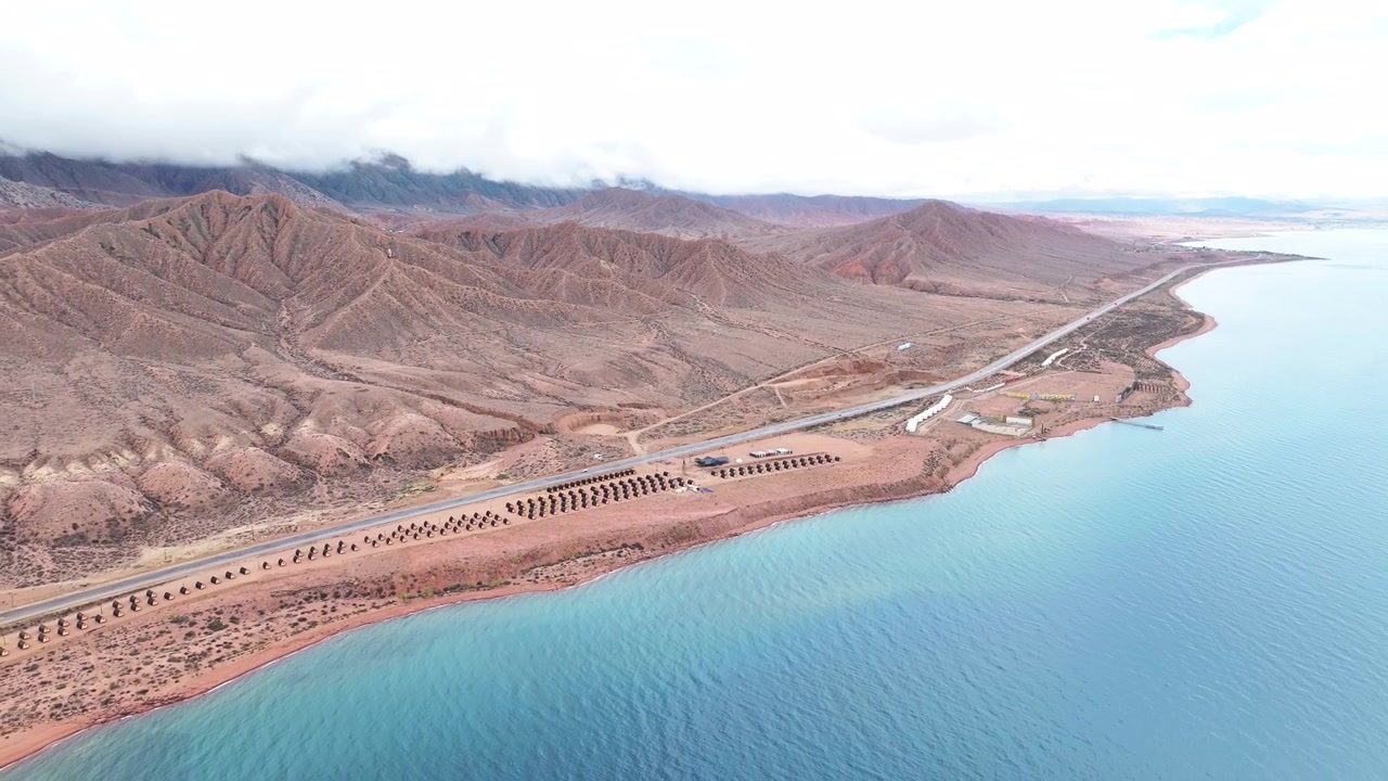 Veduta aerea panoramica del campeggio sul lago Issyk-Kul, sulla costa e tra montagne rocciose, paesaggio naturale del Kirghizistan