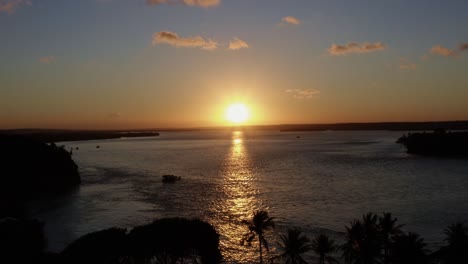 dolly en un dron aéreo toma panorámica de la enorme laguna tropical de guaraíras con un ferry en la famosa ciudad costera de tibau do sul durante una colorida puesta de sol dorada cerca de pipa brasil en río grande do norte