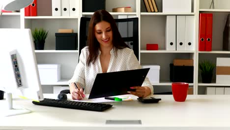 mujer de negocios morena trabajando con documentos en una oficina ligera