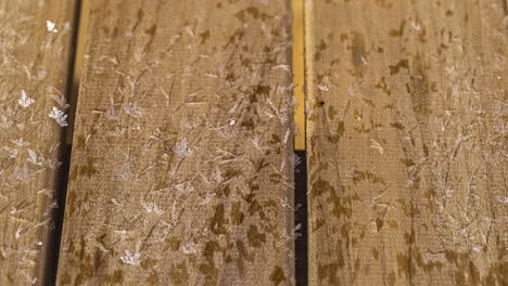 Time-lapse-shot-of-wooden-terrace-freezing-during-cold-winter-day-outdoors---top-view