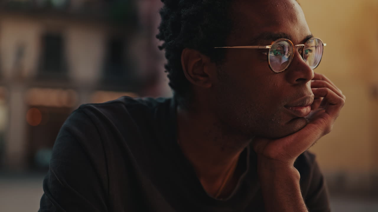Close-up of Thoughtful Young Black Man Wearing Glasses