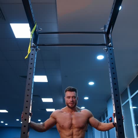 shirtless male athlete walks to the horizontal bar for training. selective focus on bodybuilder. slow motion