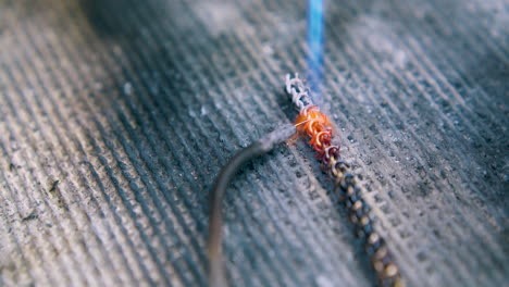 jeweler works with metal chain using gas burner close view