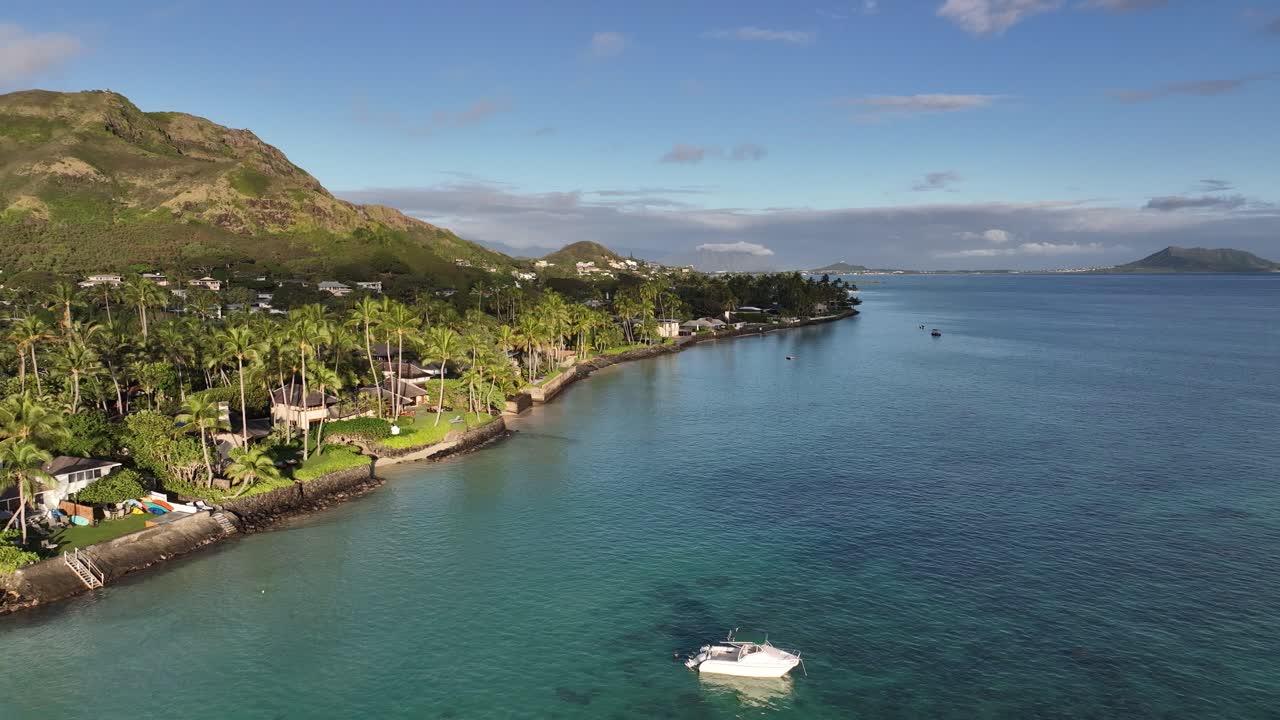60fps slow mo drone riprese aeree con drone sopra lanikai beach case su oahu hawaii con palme acqua blu montagne in barca all'alba con tanto sole
