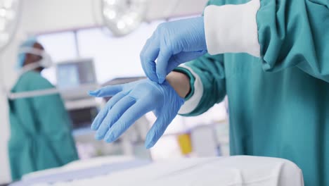 Video-Des-Mittelteils-Eines-Chirurgen,-Der-Im-Operationssaal-OP-Handschuhe-Anzieht