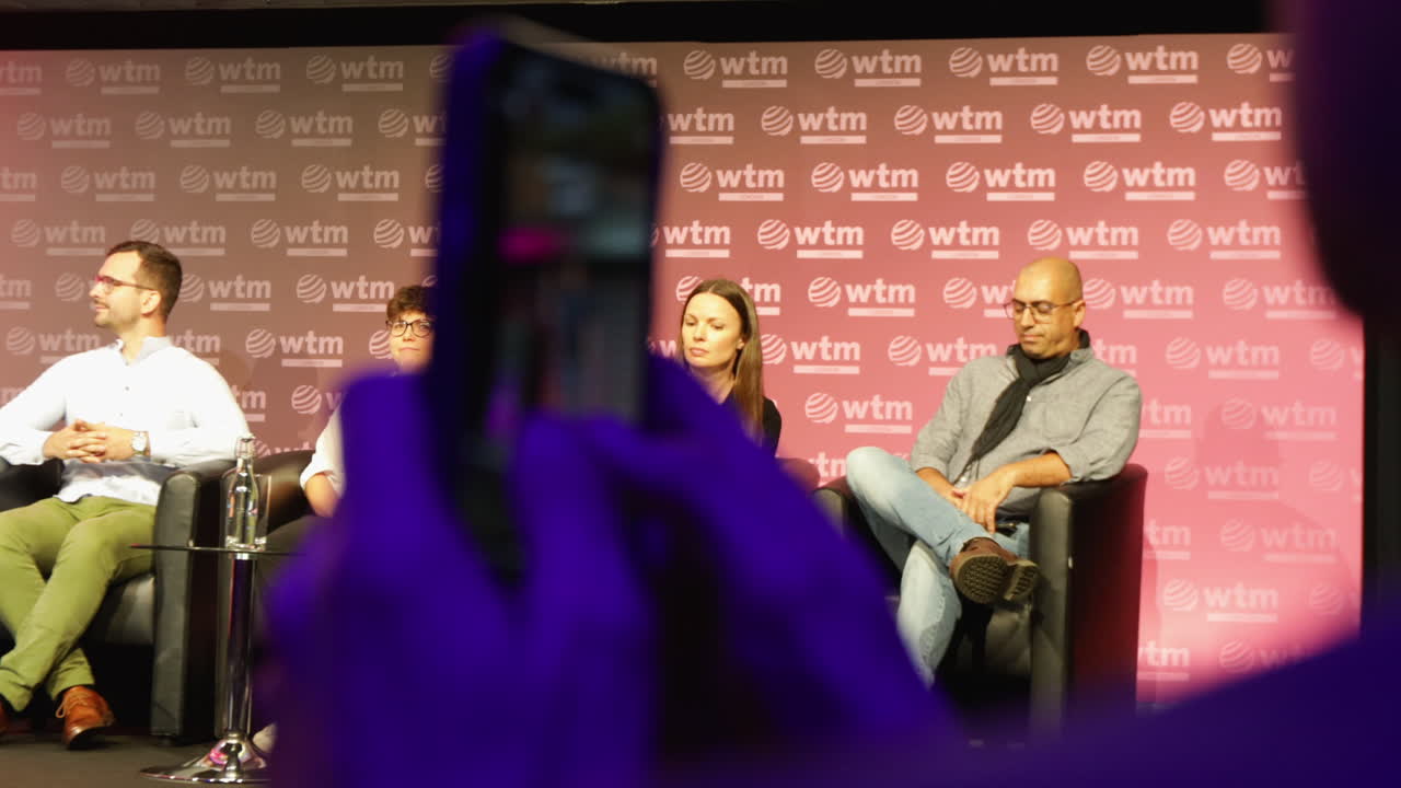Man In The Audience Photographs On Stage Speakers At World Travel Market Convention In London.