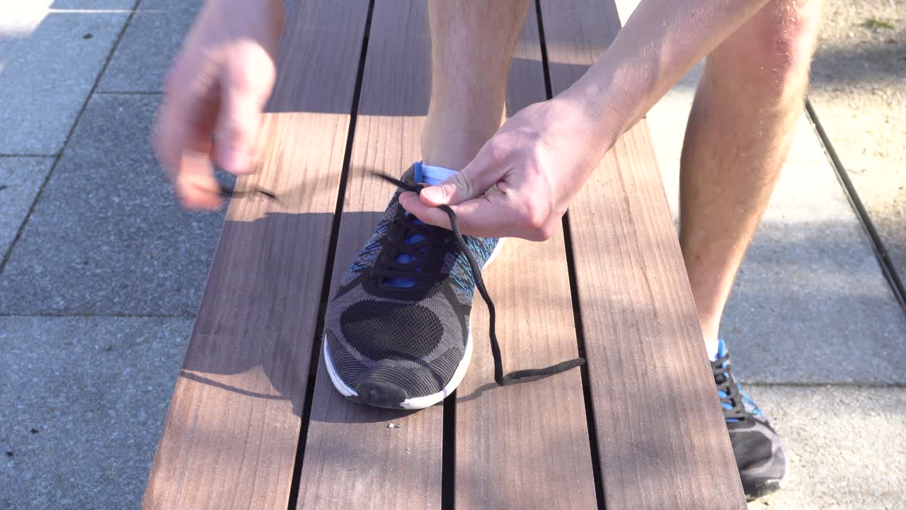 Un corridore si sta allacciando le scarpe