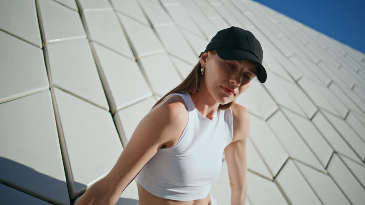 Athletic woman leaning wall modern textured building feeling calmness closeup