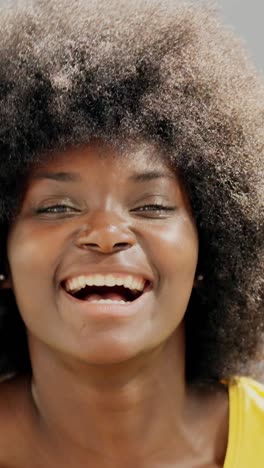 close-up portrait of a happy young black woman with an afro laughing