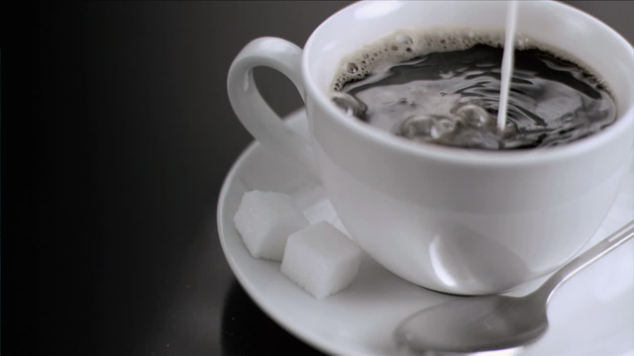 la leche fluye en cámara súper lenta en el café.