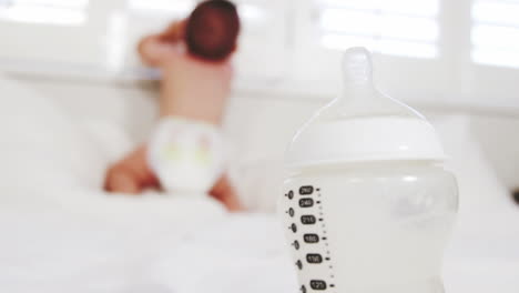 un bebé está de pie en una cama