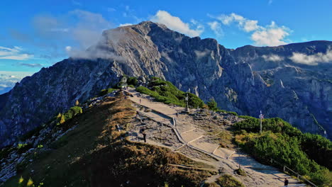 Right-to-left-pan-shot-of-the-Eagle-nest-Kehl-Steinhaus,-Berchtesgaden,-Germany-with-visible-mountain-peaks-and-walking-train-with-stairs