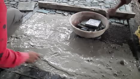 workers performing floor application with concrete for fixing small stones