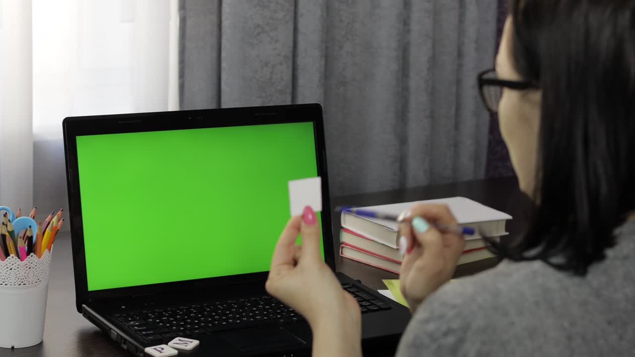 maestra haciendo llamada de video de educación a distancia en línea en la pantalla verde de la computadora portátil