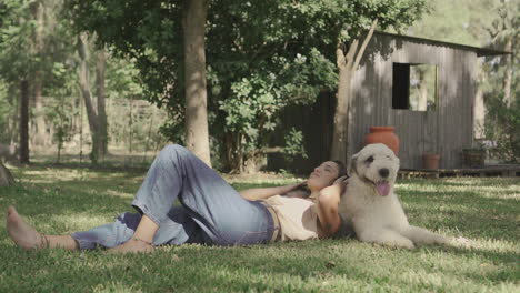 female lying with her big dog on the grass