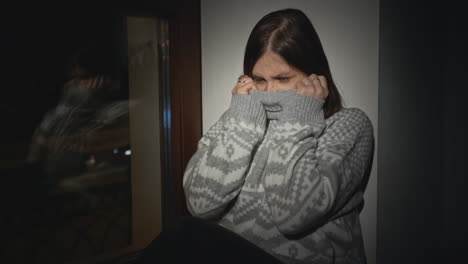 mujer triste junto a la ventana por la noche