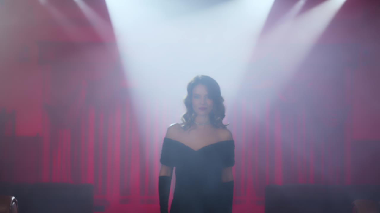 a mysterious and beautiful woman in an evening dress and high heels climbs the stairs into the smoky room