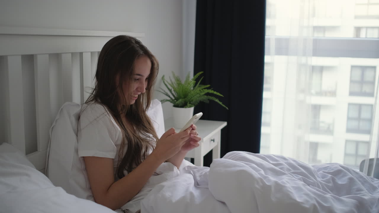mujer en la cama usando un teléfono inteligente