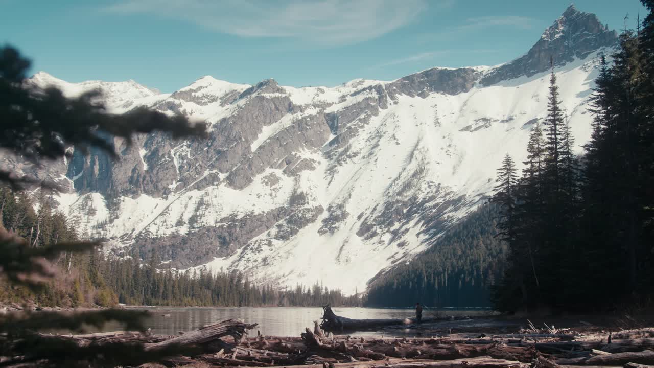 increíble panorámica de un pequeño excursionista solitario en medio de una hermosa vista de las montañas y el lago