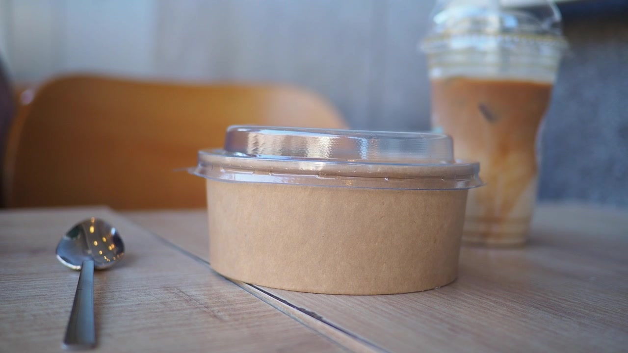 Hand Picking Up Disposable Kraft Paper Food Container