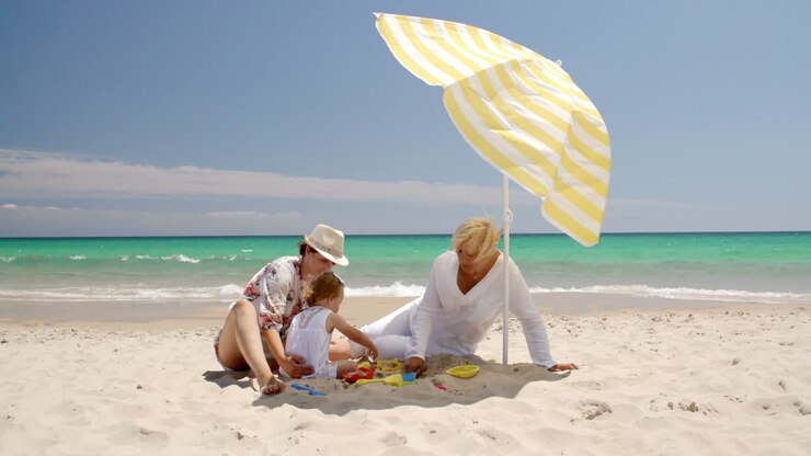 nonna, mamma e la bambina giocano sulla spiaggia.