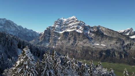 Establish-shot-Alps-Mountains-range-snow-on-top-spruce-trees-Switzerland