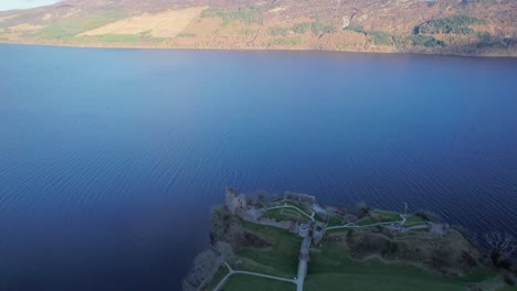 drone flying around urquhart castle, loch ness lake in scotland aerial