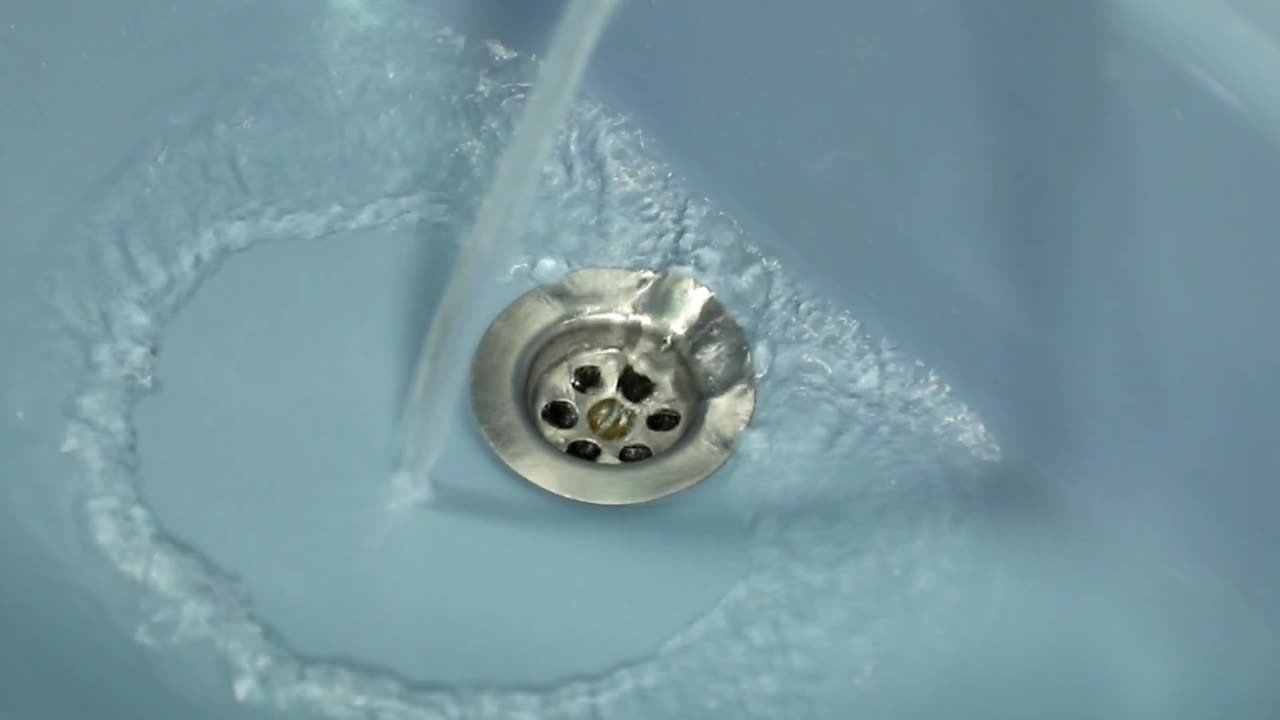 agua fresca y clara cayendo por el desagüe del baño