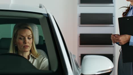 woman discussing car purchase in showroom