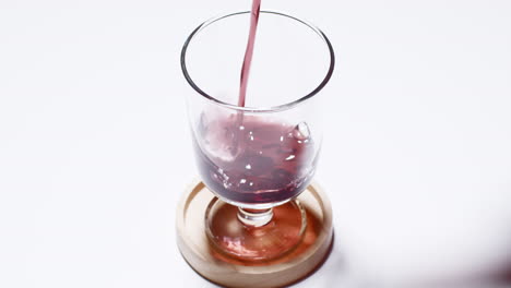 pouring grape juice into a clear cup close up shot