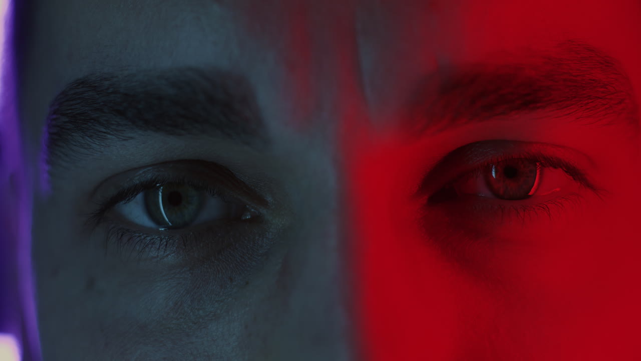 Close-up portrait of a man with contrasting colored lights