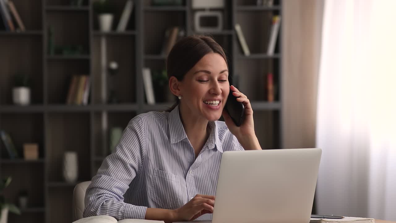 una joven empresaria muy feliz al escuchar buenas noticias durante una conversación en su teléfono inteligente.