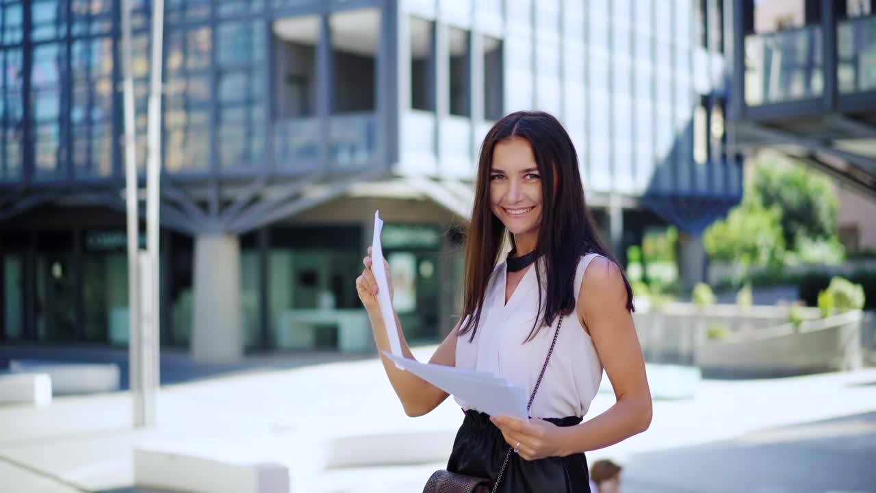joven feliz mujer de negocios atractiva mira a la cámara y sonríe