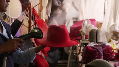 mujer de raza mixta trabajando en una fábrica de sombreros