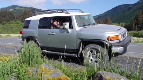 A-nature-and-wildlife-photographer-capturing-photos-while-in-a-Toyota-fj-cruiser-SUV-on-Kodiak-Island-Alaska