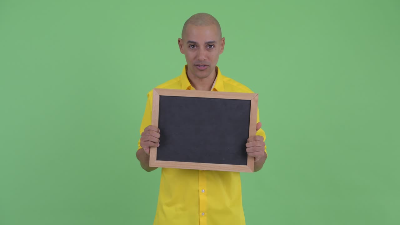 Happy handsome bald businessman with blackboard