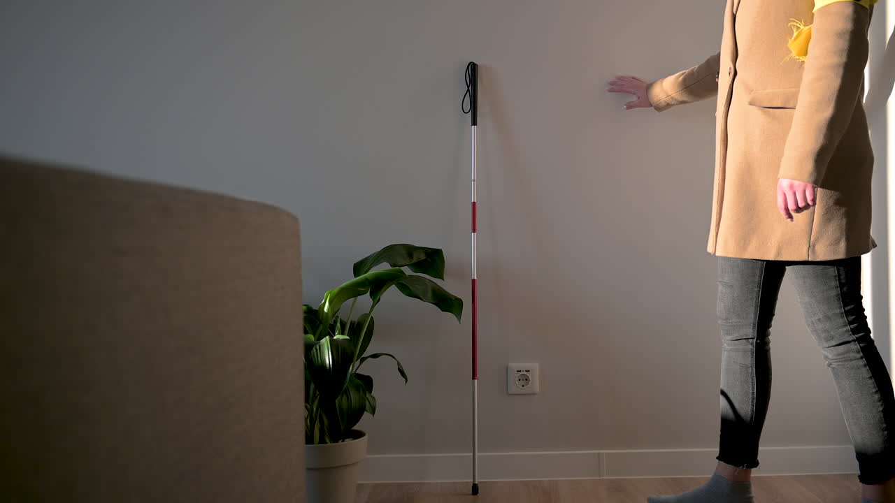 코트와 완장을 들고 지팡이를 들고 집을 떠나는 알아볼 수 없는 여성