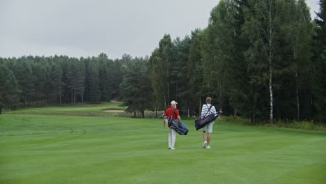 two golfers walking on a golf course