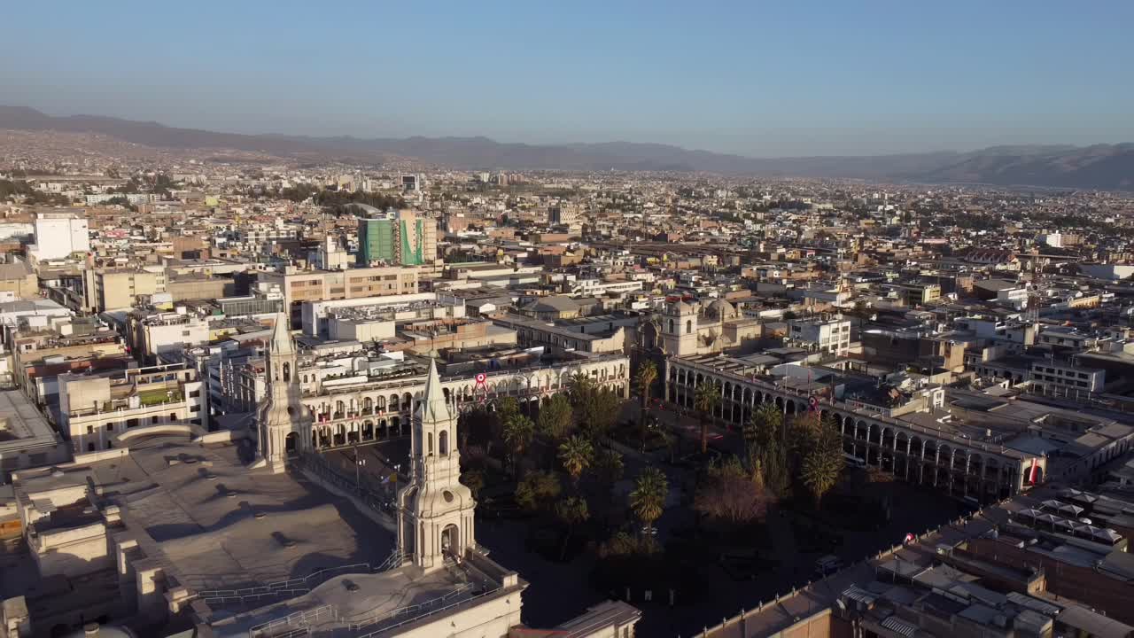 Aerial drone overview of Arequipa, Peru, showcasing the city's architecture and surrounding volcanic landscape in warm sunlight