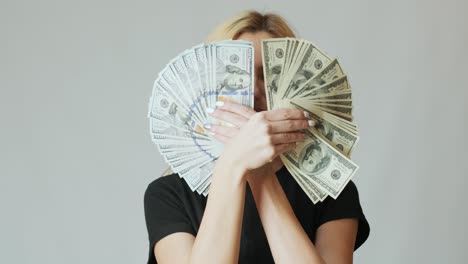 beautiful girl with a lot of dollars in the hands on the white background