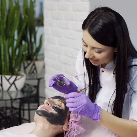 cleansing face mask. woman receiving cosmetic procedure in beauty salon.