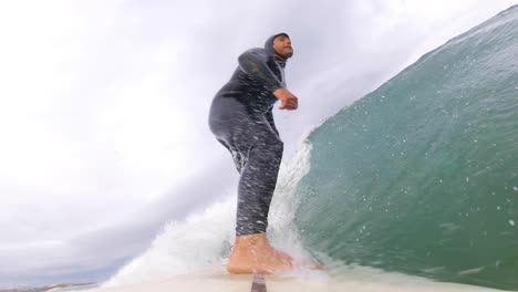 view of some strong rider generating some speed on a perfect wave with a strong reentrie off the lip in praia da adraga, sintra, portugal