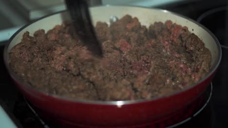 Ground-Beef-Being-Cooked-with-Spatula-in-Red-Pan