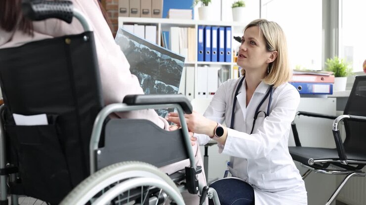 Doctor examining patient&#039;s X-ray in wheelchair