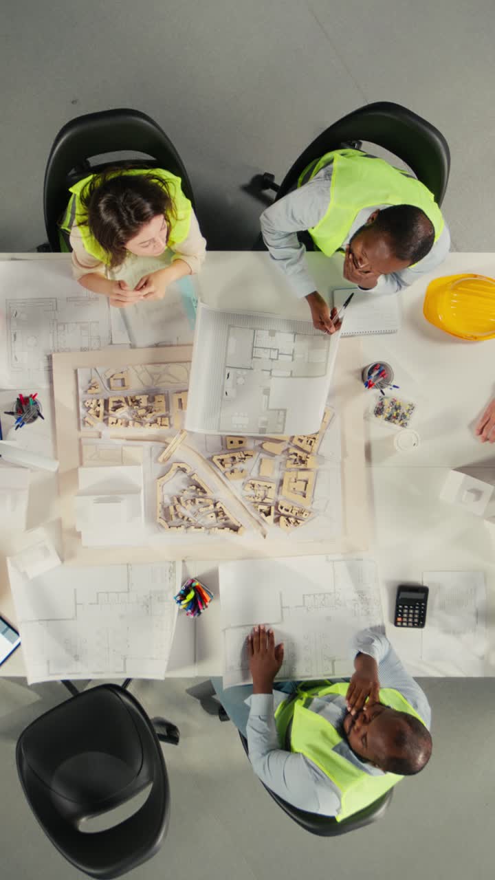 Vertical Video Top down view zoom out of property developers and architects in meeting