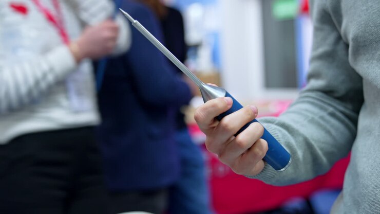 Male hand holding and turning a medical tool. Unrecognized student displaying an instrument for neurosurgery. Close up.