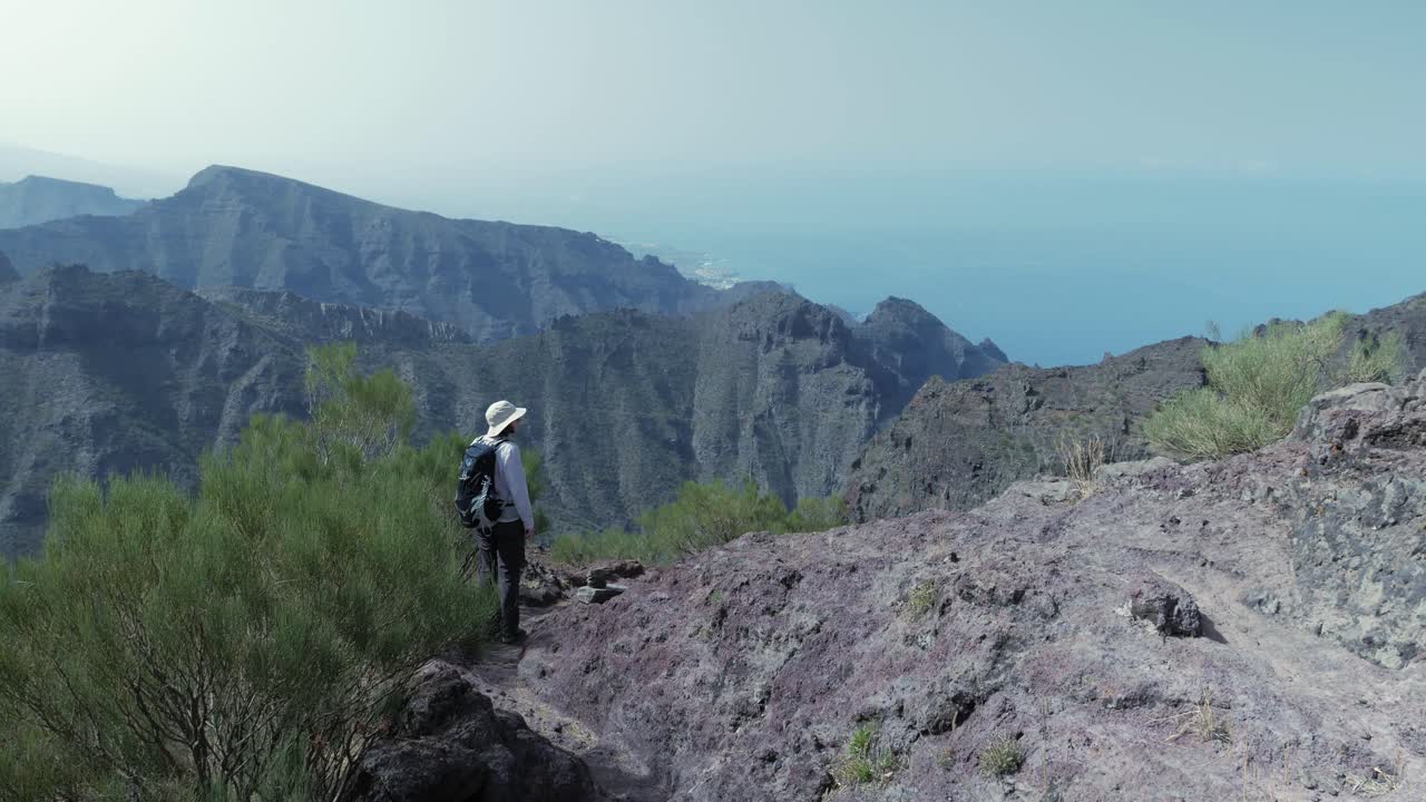 mujer excursionista en las montañas de tenno, tenerife, disfrutando de la vista panorámica sobre el océano