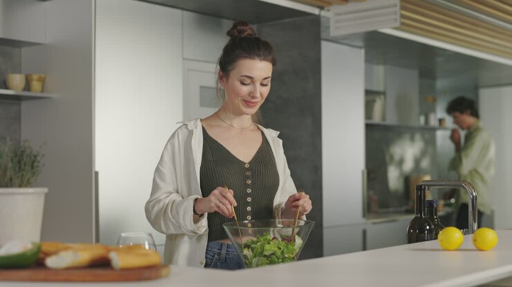 mujer preparando una ensalada saludable en una cocina moderna